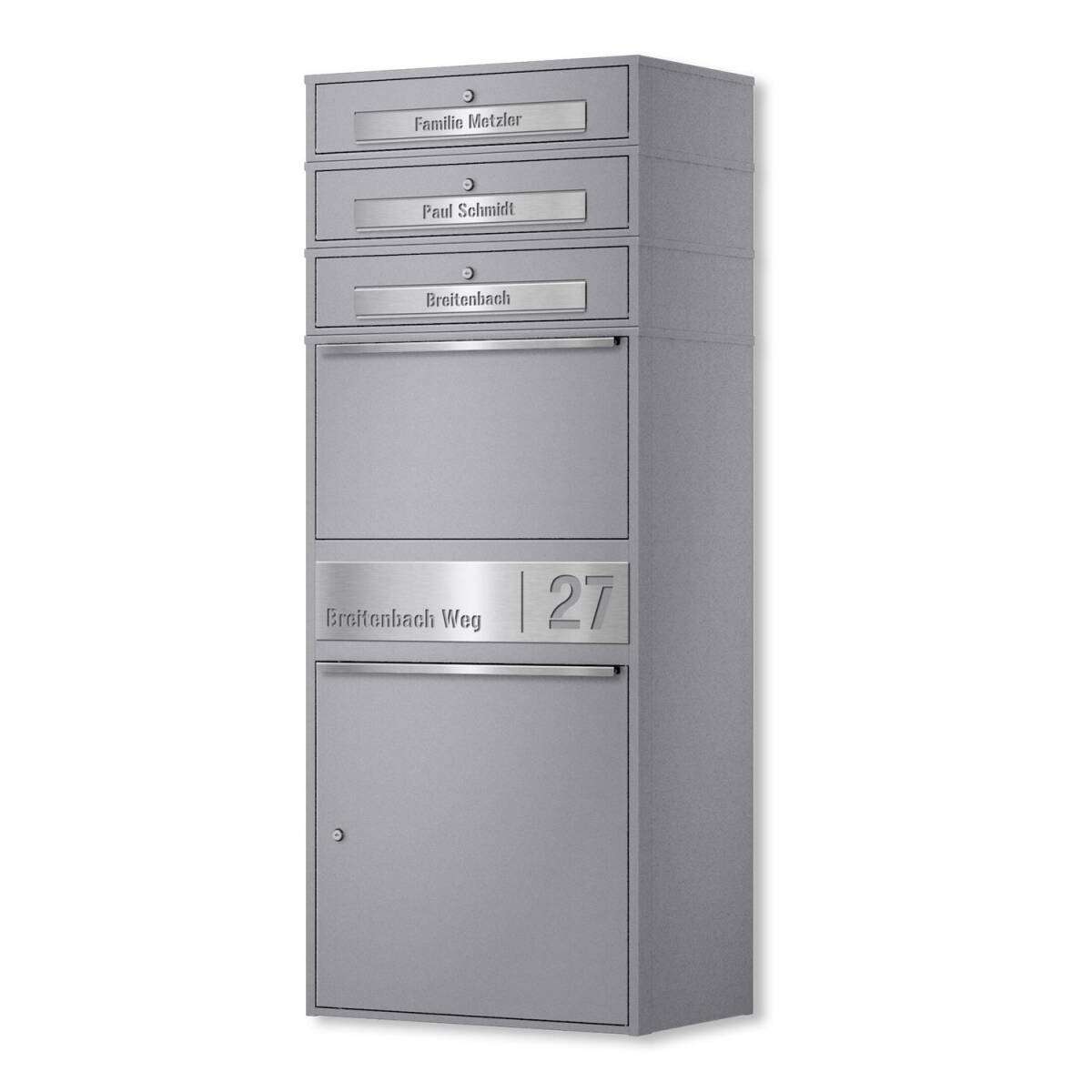 Gray metal multi-mailbox unit with four small mail slots at the top and a larger bottom compartment; address plaque reads Breitenbach Weg 27.
