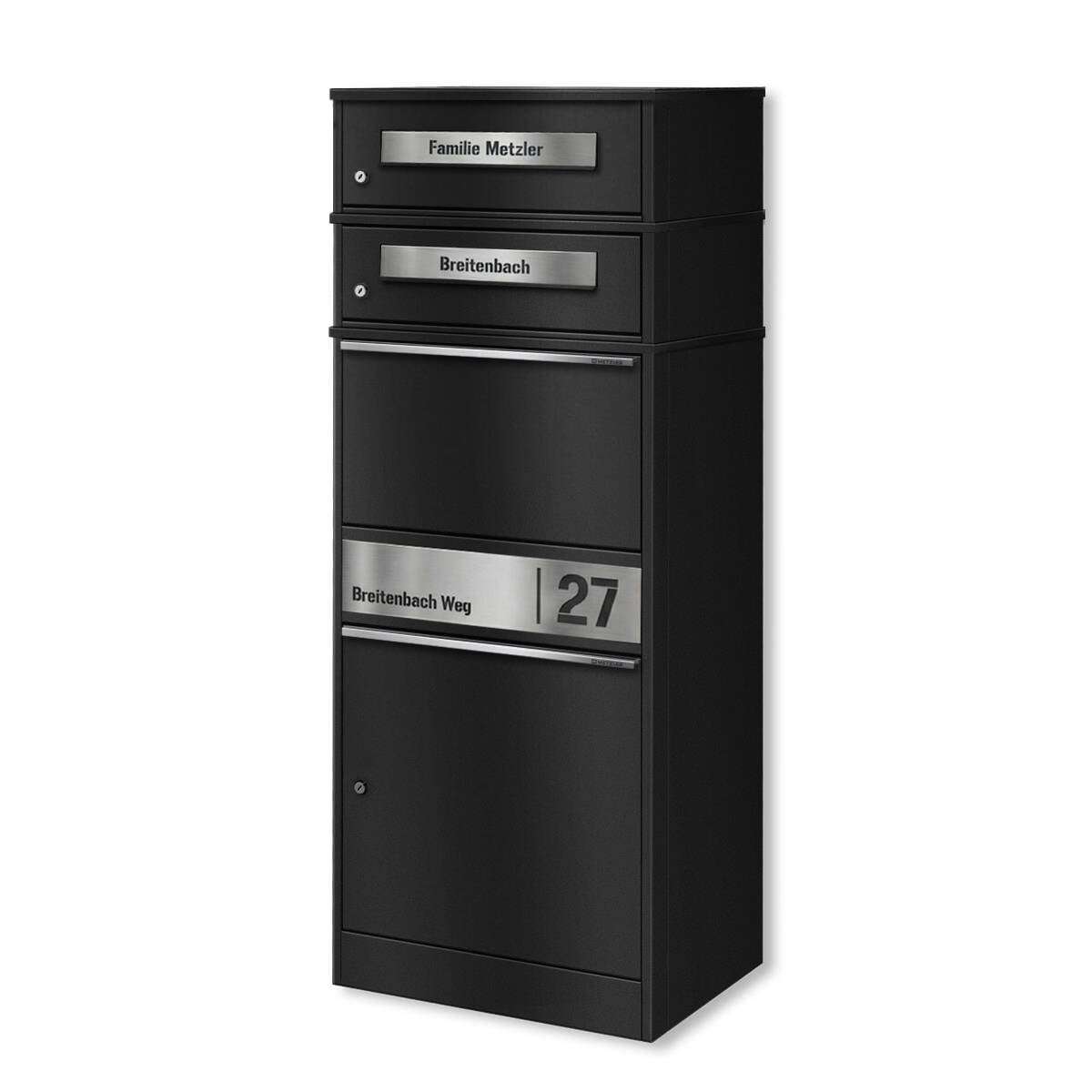 Tall black freestanding mailbox with multiple compartments, featuring metal nameplates on the top drawers and a large address panel reading Breitenbach Weg 27.
