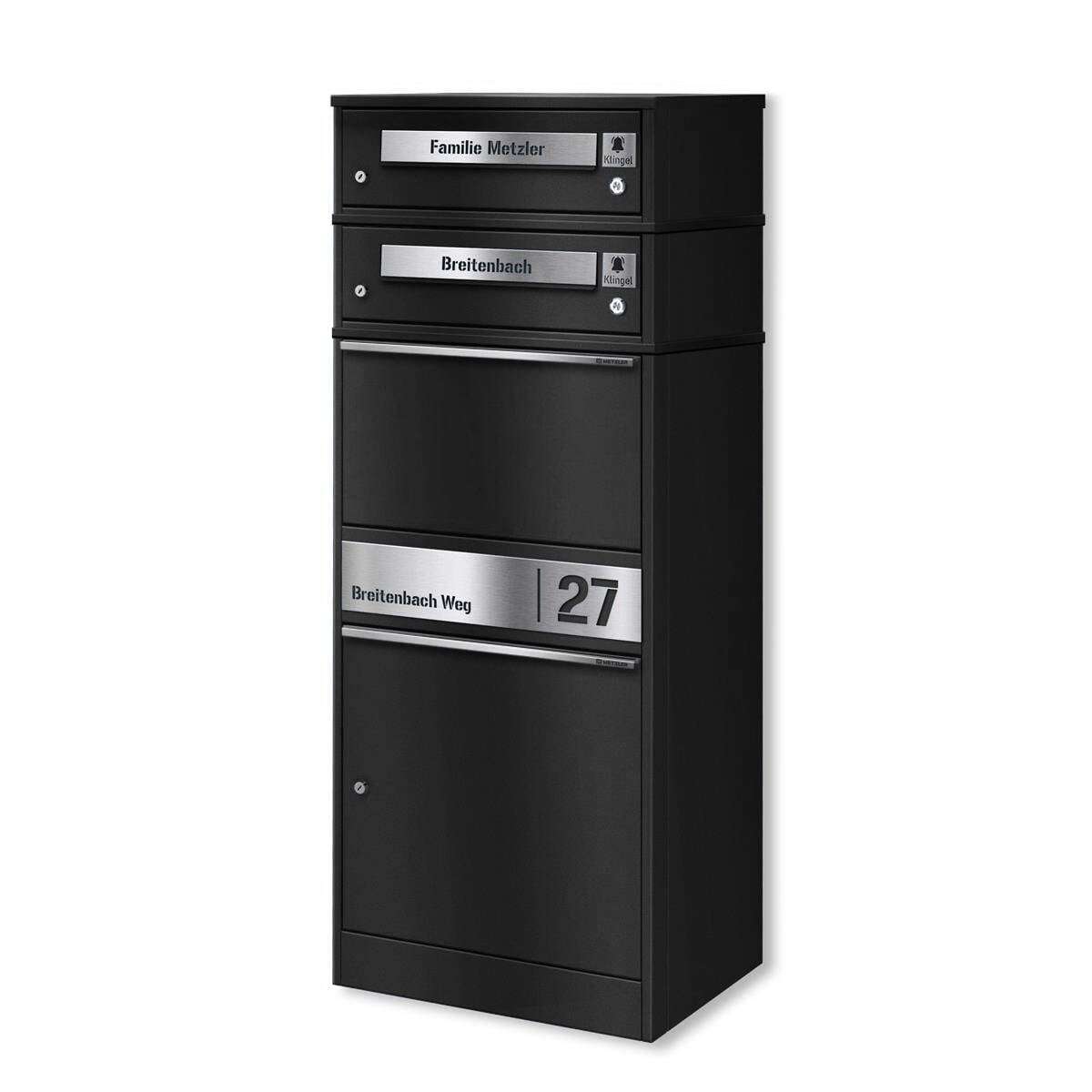 Black multi-compartment mailbox unit with nameplates and a street-number panel showing 'Breitenbach Weg 27' and two top compartments labeled with 'Familie Metzler' and 'Breitenbach'