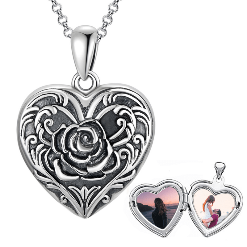 Silver heart-shaped locket necklace with intricate rose filigree; opens to reveal two photo inserts.