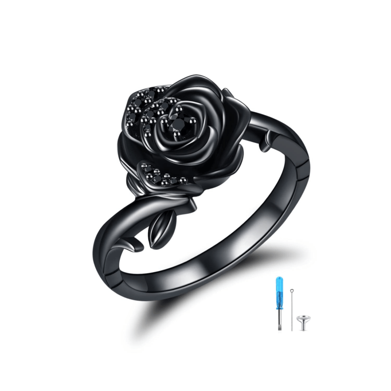 Black metallic ring featuring a glossy rose motif with embedded dark stones, photographed against a white backdrop.